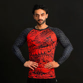 Man wearing a red and black dragon-themed long-sleeve shirt on a black background