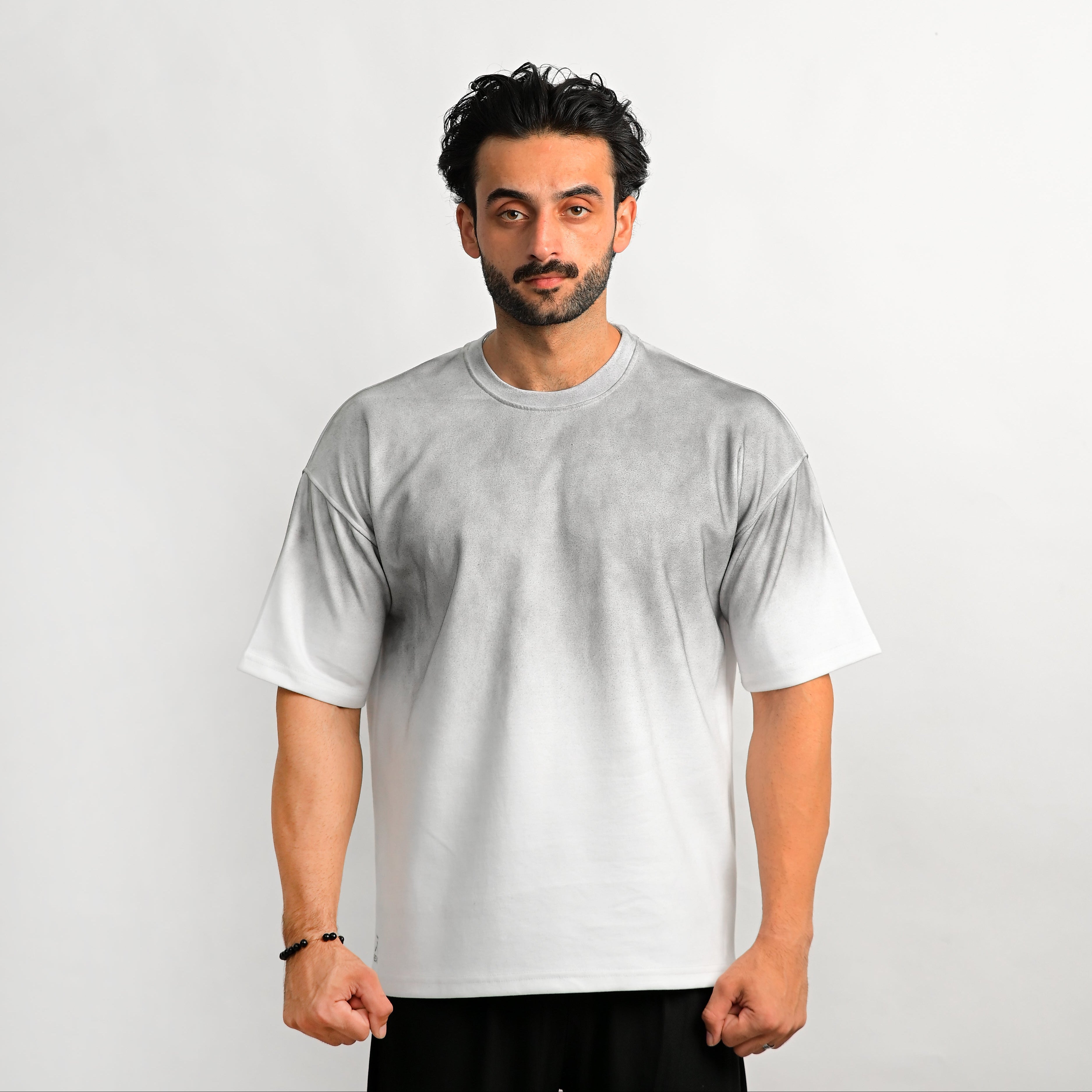 Man wearing a plain white t-shirt against a light gray background
