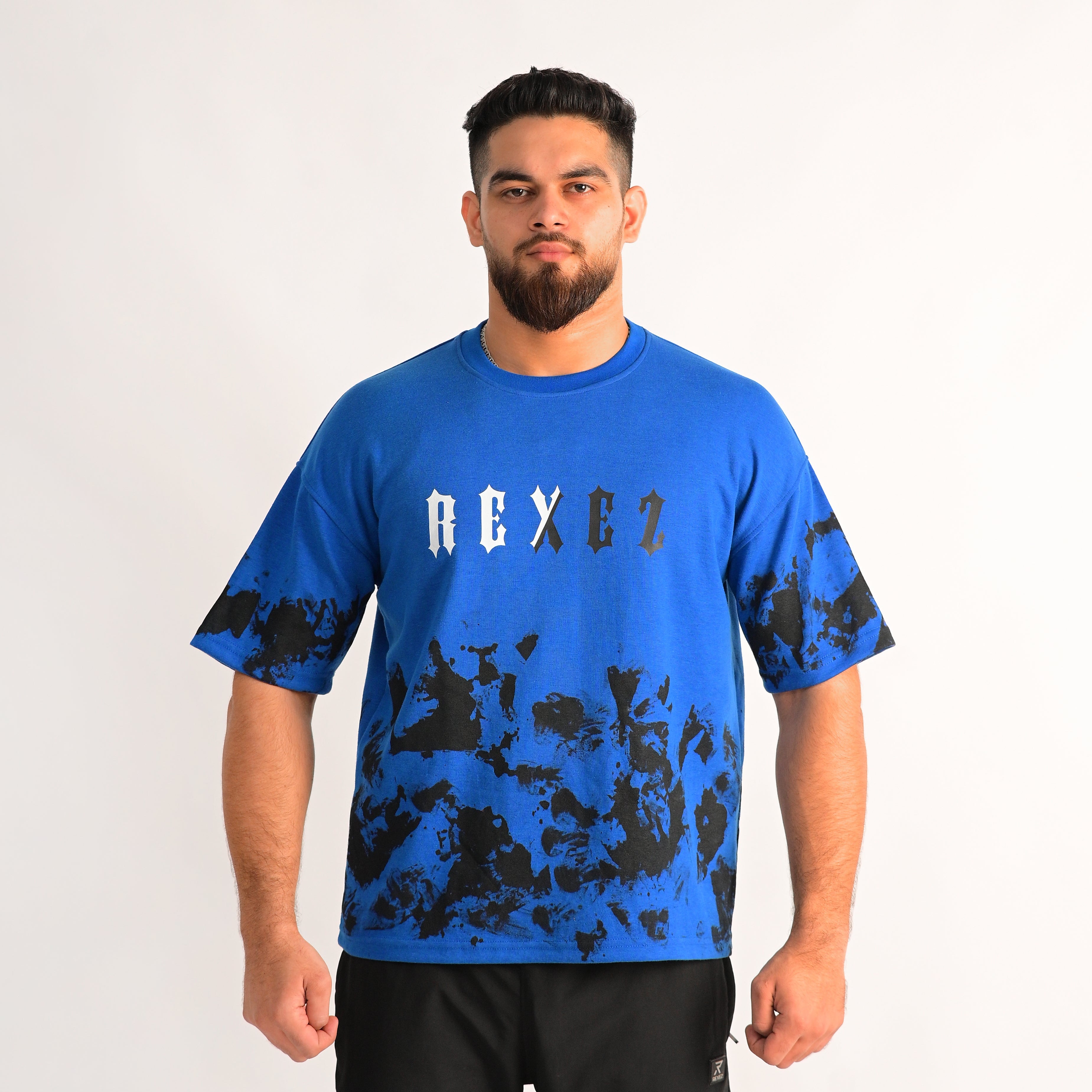 Man wearing a blue t-shirt with black abstract design and 'AEXEZ' branding on a white background