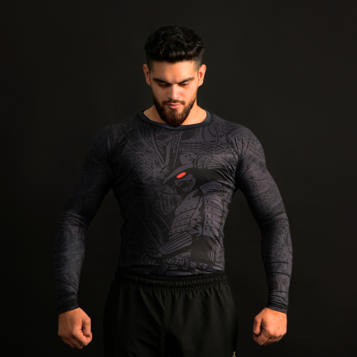 Man wearing a black athletic shirt with a design on a dark background