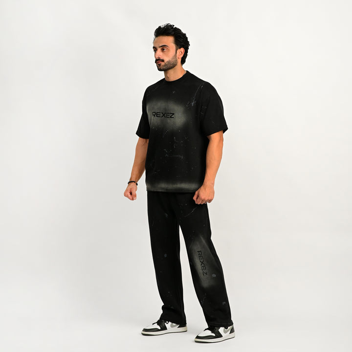 Man wearing a black t-shirt and pants with 'REXEZ' branding on a white background