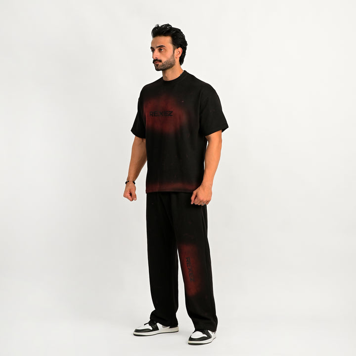 Man wearing a black outfit with red accents on a white background