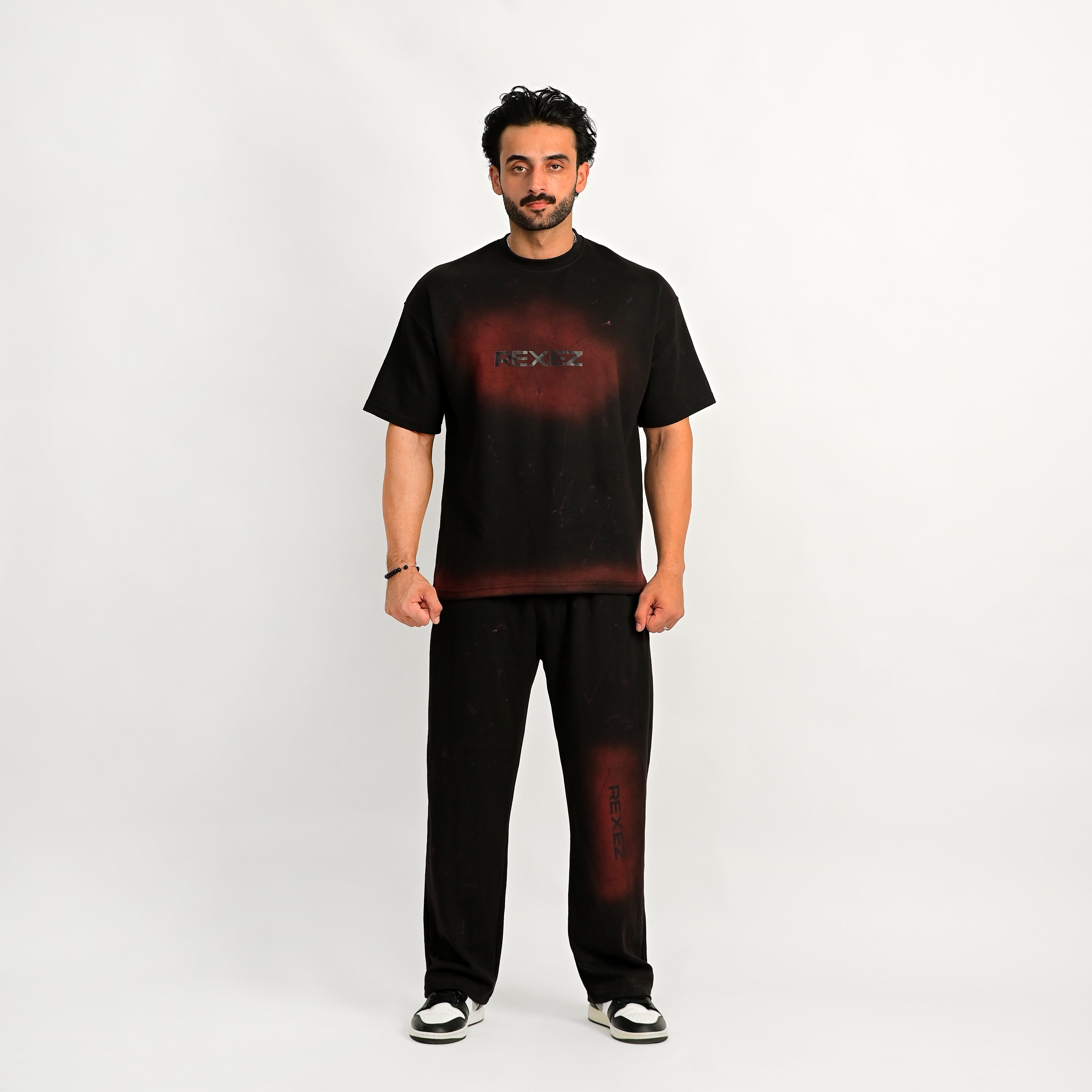 Man wearing a black t-shirt with a red graphic and text on a white background