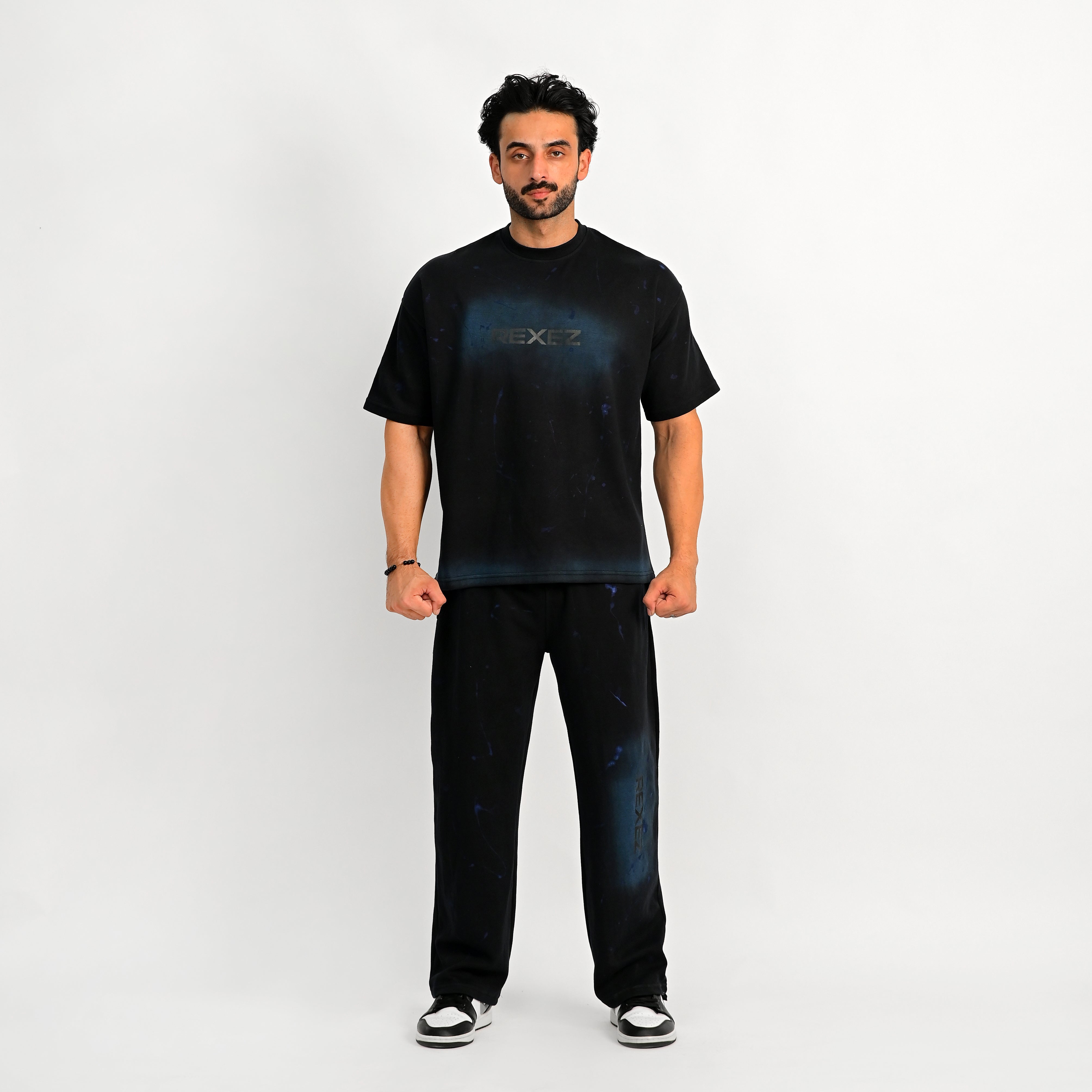 Man wearing a black t-shirt and jeans on a white background