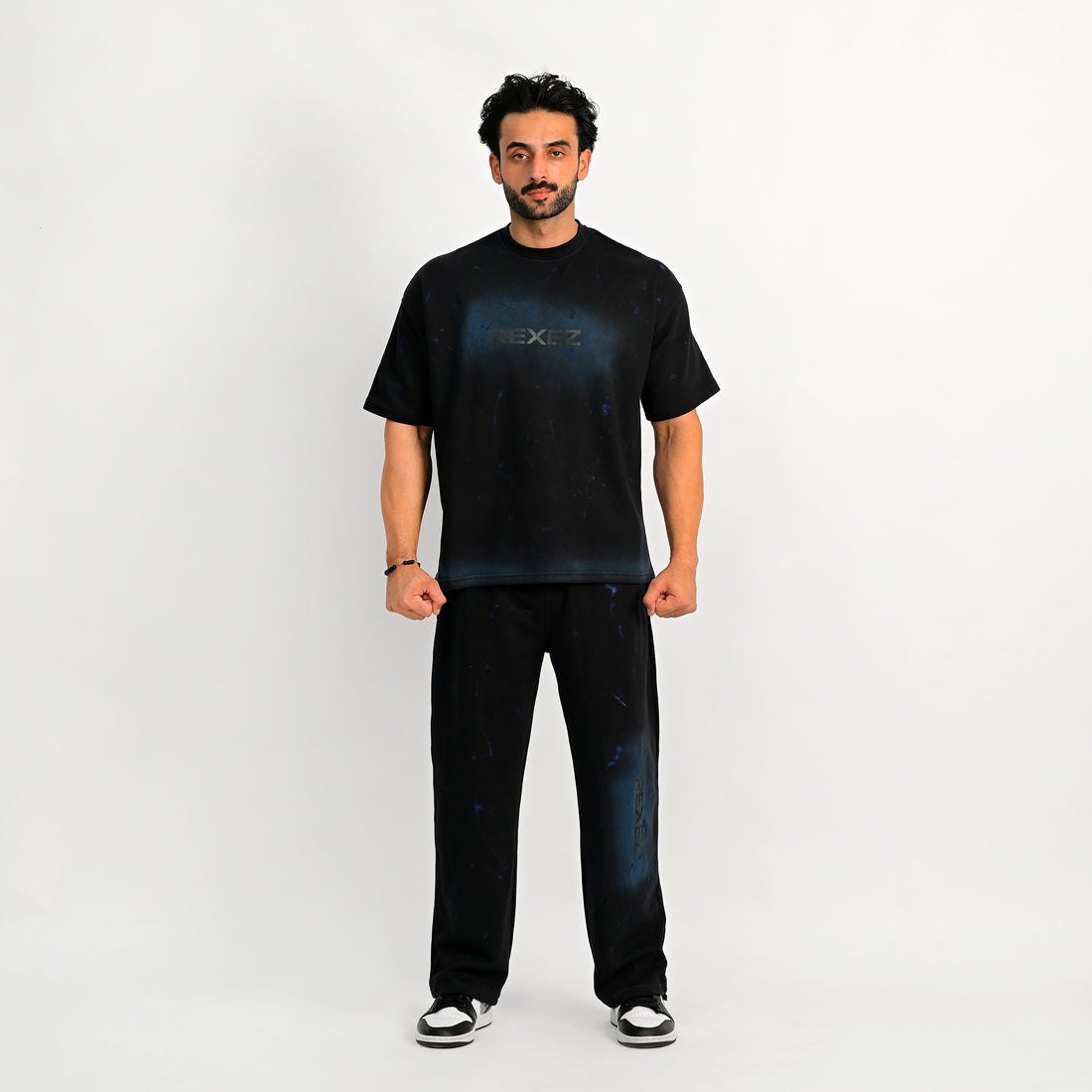 Man wearing a black t-shirt and jeans on a white background