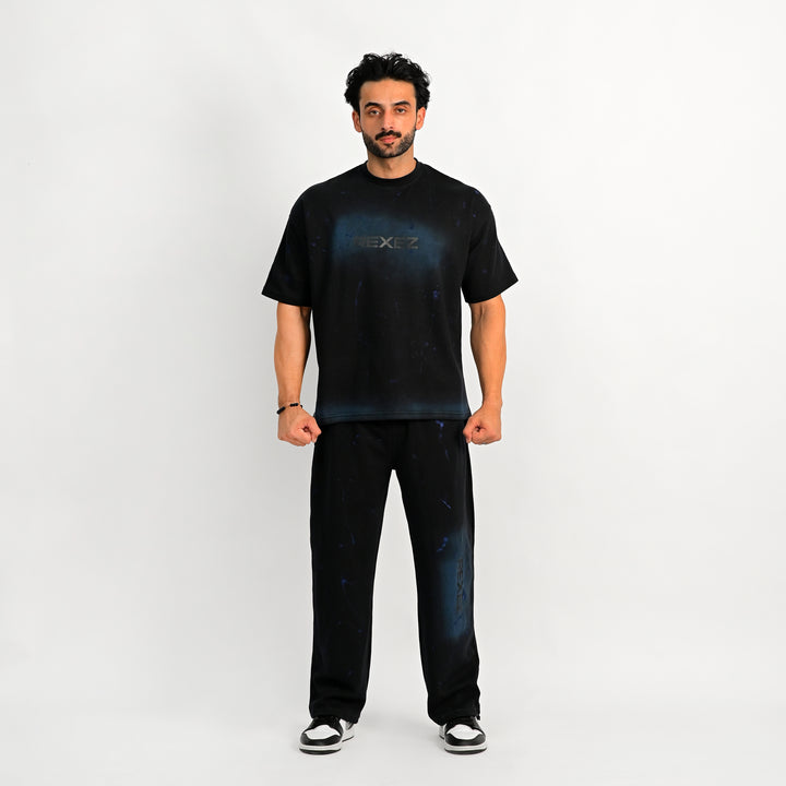 Man wearing a black t-shirt and jeans on a white background