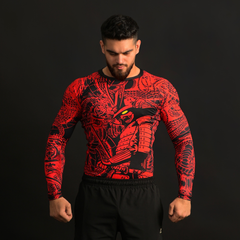 Man wearing a red and black patterned long-sleeve shirt on a black background