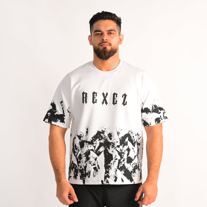 Man wearing a white t-shirt with black abstract patterns and 'REXEZ' branding on a plain background