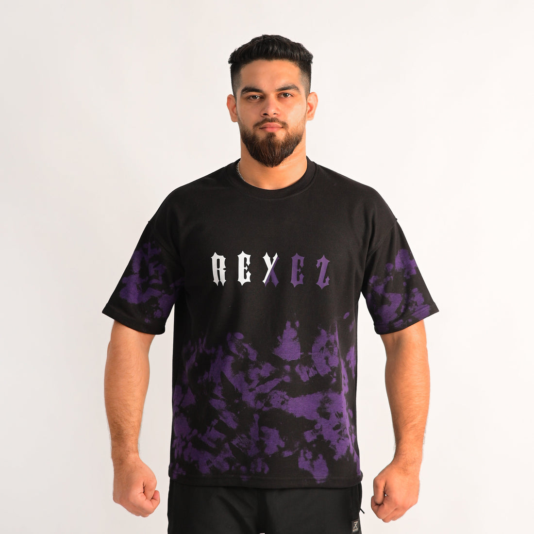 Man wearing a black t-shirt with purple camouflage patterns and 'REX EZ' text on a white background