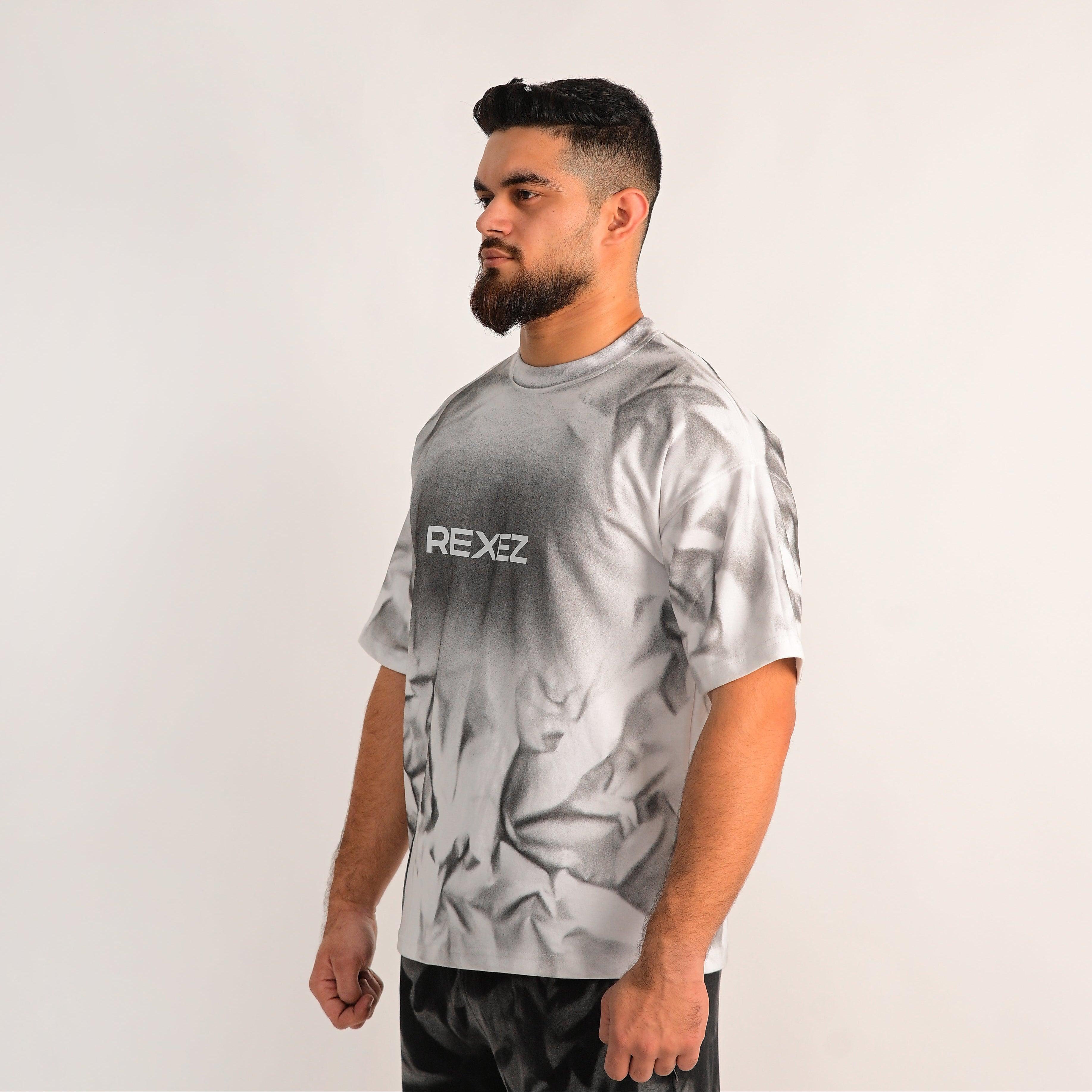 Man wearing a gray t-shirt with 'REXEE' logo on a white background