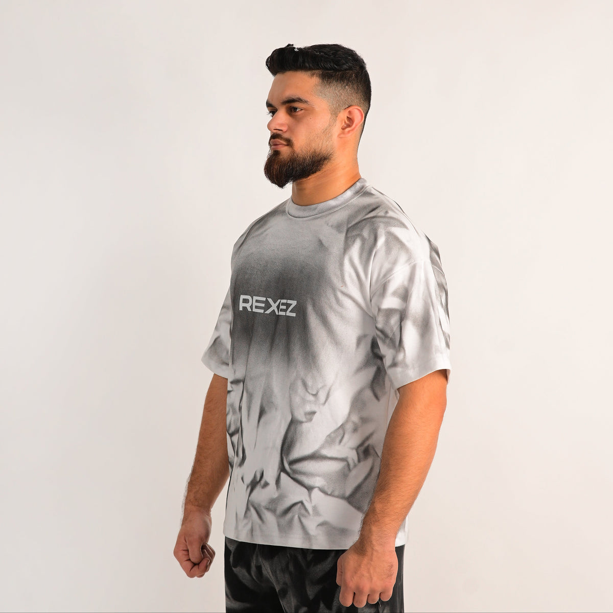 Man wearing a gray t-shirt with 'REXEE' logo on a white background