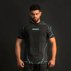 Man wearing a black outfit with green accents on a black background